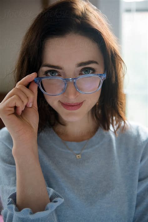woman peeking over eyeglasses by stocksy contributor jamie grill