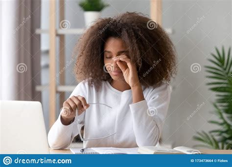 African Teen Girl Rubbing Eyes Tired From Computer Holding Glasses