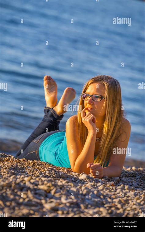 Blonde Teen Teenager Girl Lying On Stomach On Beach Wearing Spectacles