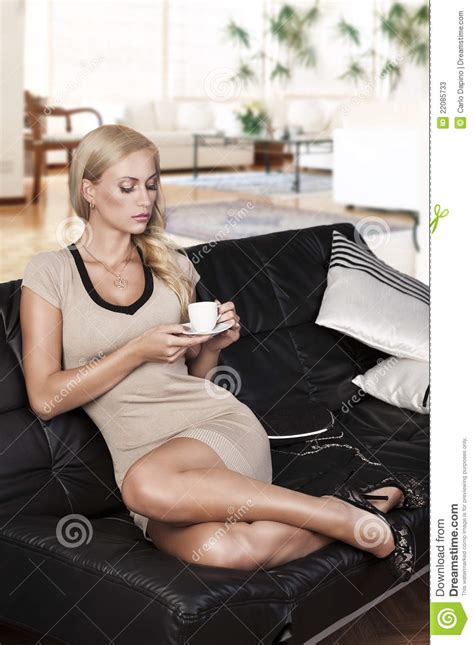 sitting on sofa drinking from a cup stock image image of couch interior 22085733