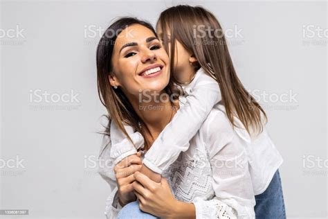 portrait of daughter kissing her mother isolated on white background