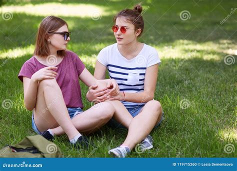 Women Lesbians Have Fun Together While Sit Crossed Legs On Green Grass
