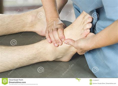 physiotherapist chiropractor doing a feet massage to man patient