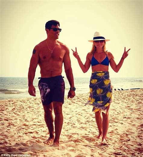 kelly ripa is fit in bikini top as she flashes peace sign with husband