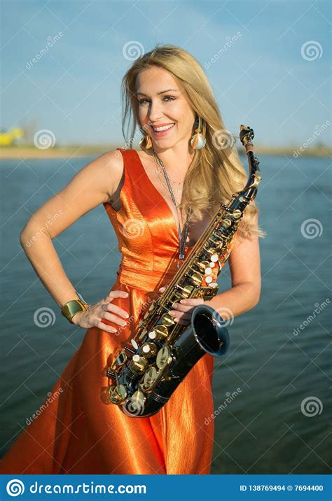 Girl With Sax Smiles Flirts Happy Blonde Woman With Big Bust Plays