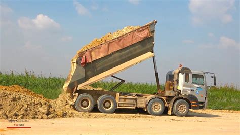 operating job construction dump truck dumping dirt  bulldozer