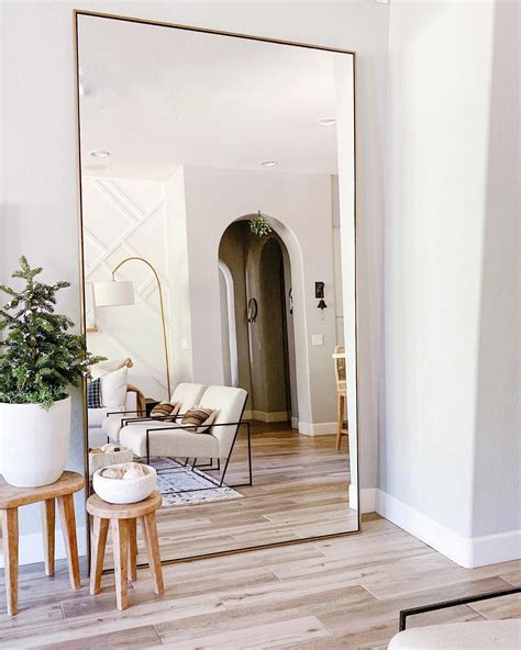 linnea floor mirror in brass—arhaus big mirror in bedroom apartment