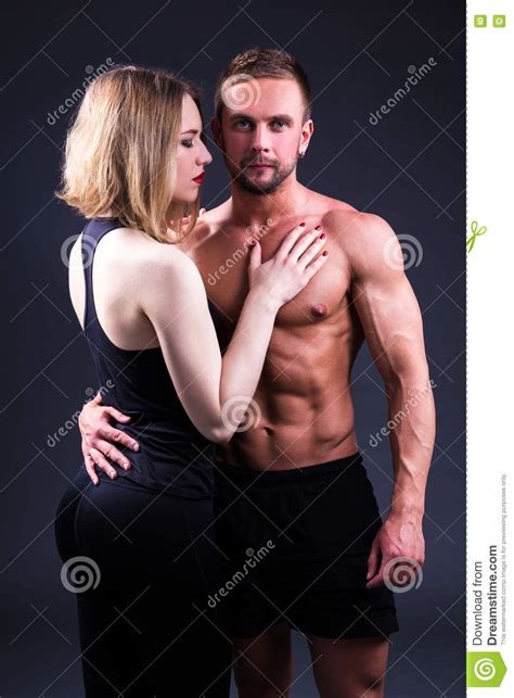 liebes und sportkonzept sexy frau und muskulöser mann über grau stockfoto bild von