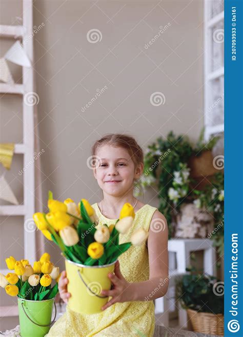 portrait of teen girl in yellow dress with bouquet of tulips stock
