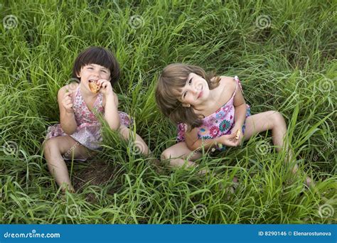 Deux Filles Sasseyant Dans Lherbe Photo Stock Image Du Fille