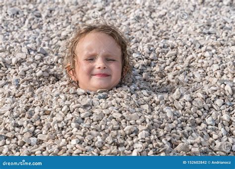 child buried   stones  head    stock photo