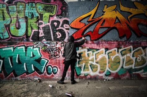 image  teenage graffiti artist spray painting  wall austockphoto