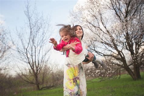Mom Throws Daughter Plays On The Background Of Blue Sky Stock Image