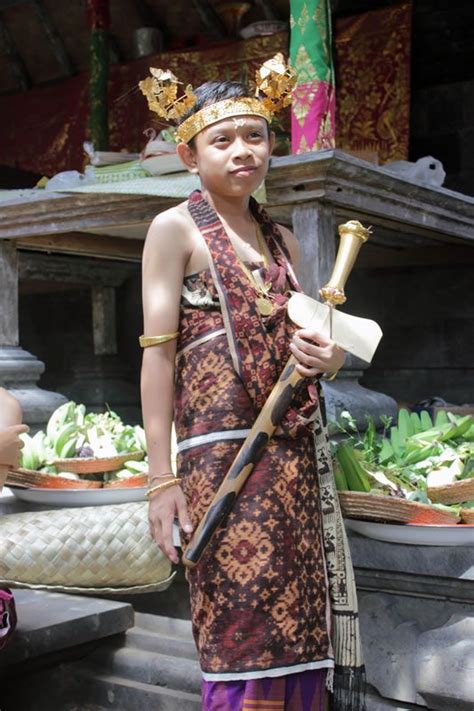young male initiate dressed  full traditional dress  carrying