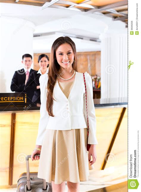 Asian Chinese Woman Arriving At Hotel Front Desk Stock