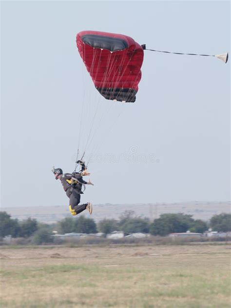 mannetje die skydiver voor helder het landen op gras met open binnenkomen redactionele stock