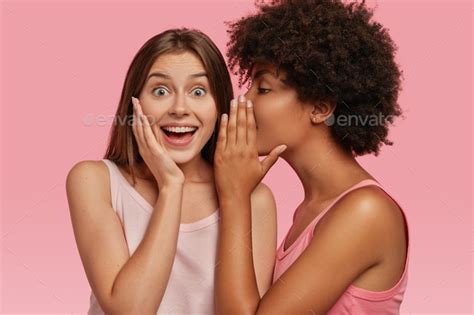 Young Black Woman Whispers Secret To Her Caucasian Friend Gossip