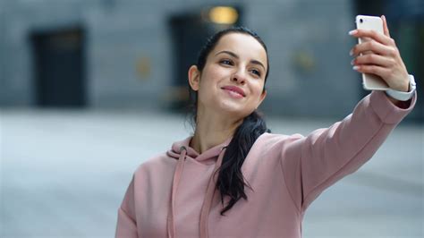 close up smiling woman waving hand to smartphone camera happy girl