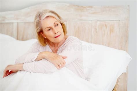 Relaxed Mature Woman In Bed Looking Away Portrait Of A Relaxed Mature
