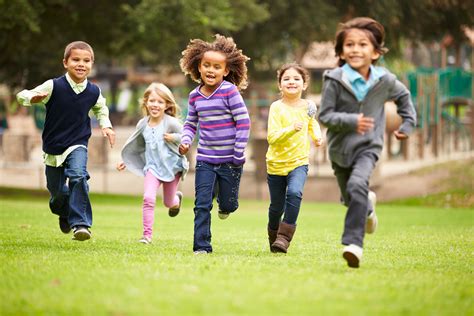 group  young children running  camera  park quils