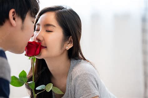 Premium Romantic Asian Couple In Bedroom A Man Giving A Rose To