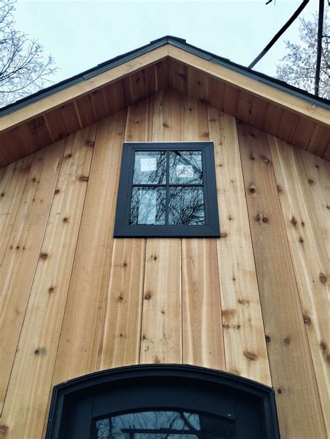raw cedar vertical siding bronze windows arched door vertical siding house exterior