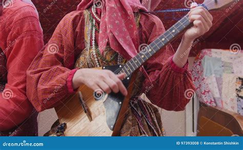 volksmuziek russisch ensemble vrouw die  russisch volkskostuum de balalaika spelen stock