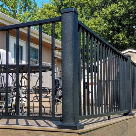 A Deck With Wrought Iron Railings And Chairs On The Back Porch In Front