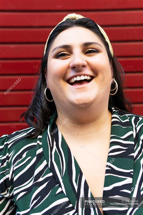 Portrait Of Cheerful Young Curvy Brunette In Stylish Striped Outfit And
