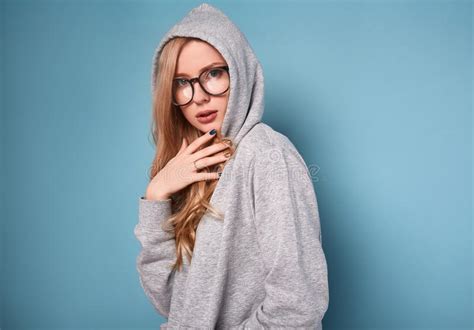 cute positive blonde woman in gray hoodie and glasses