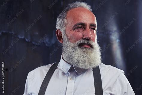 portrait of good looking mature man with gray bearded over backg stock