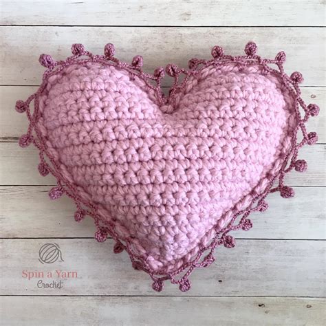 crochet heart pillow pattern holding  strands  yarn