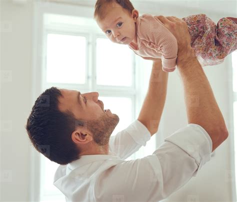 young father holding  baby girl    air stock photo  youworkforthem