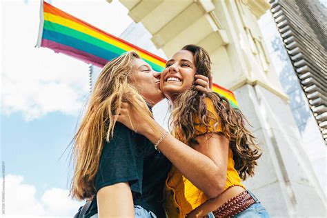 teen girls kissing under a lgbt flag by stocksy contributor victor