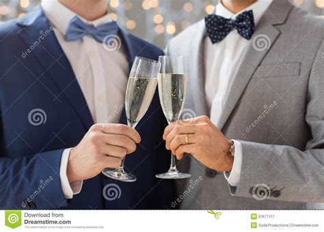 close up of male gay couple with champagne glasses stock