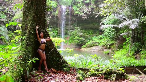 video sexy girl leaning huge tree in rainforest background waterfall ~ 12170214