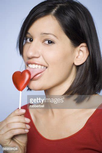 Portrait Of A Young Woman Licking A Lollipop Photo Getty Images