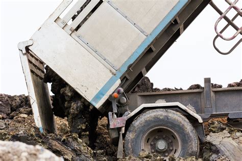 dump truck dumping soil  dirt   construction site