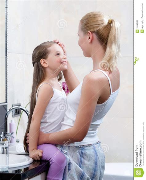 la mamá y la hija están en cuarto de baño imagen de
