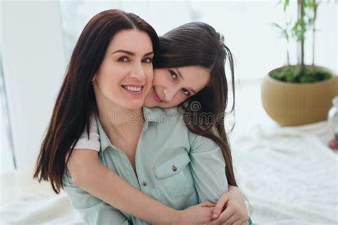 Beautiful Mother And Her Cute Daughter Smiling And Posing At Home