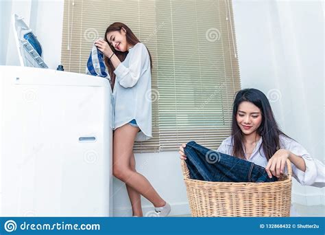 Asian Couple Women Doing Housework And Chores In Front Of Washing