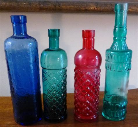 Set Of Four Old Colored Embossed Glass Bottles From French Estate