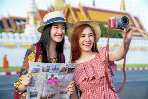 two asian girlfriends traveling and take photo in grand palace a