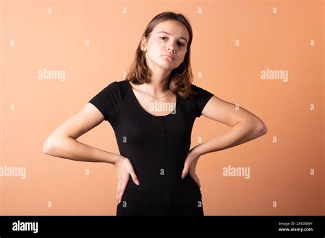 The Girl Put Her Hands On Her Hips On A Light Orange Background Stock