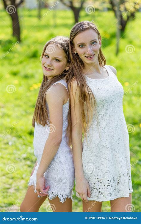 Deux Belles Jeunes Filles Dans Des Robes Blanches En été Photo Stock
