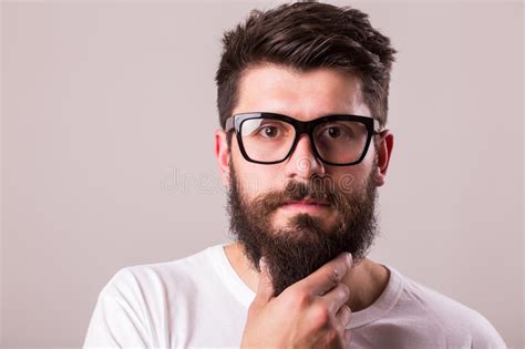 Face Portrait Of Bearded Man In Glasses With Hand On Beard