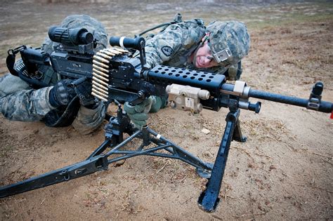 army spc benjamin clement  helps army spc antonio esparza place  mb machine gun