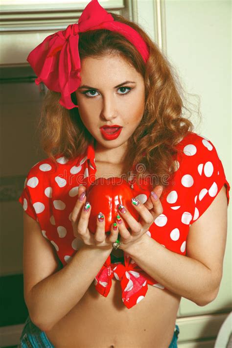 Girl In Pinup Style With Curly Hair And Nice Makeup Sits
