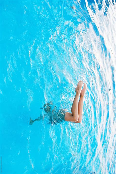 teen doing handstand with bent legs in swimming pool by wendy laurel