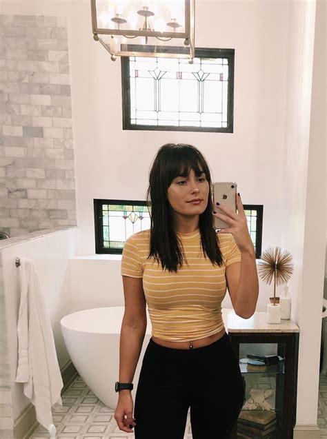 a woman taking a selfie in a bathroom with a sink and toilet behind her